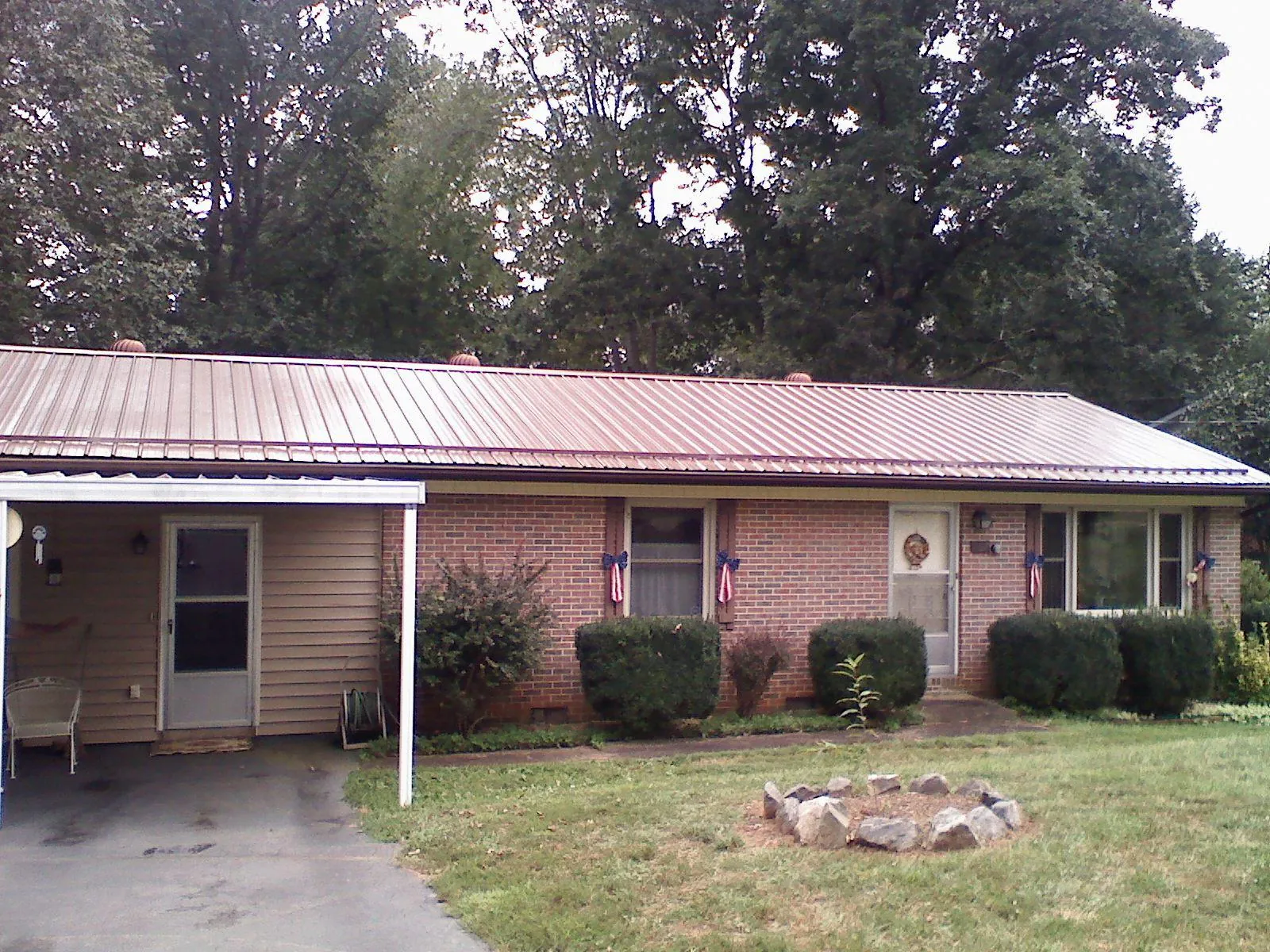 Bronze metal roof and carport on a brick ranch home — Roof Repair work by our crew in Hanahan