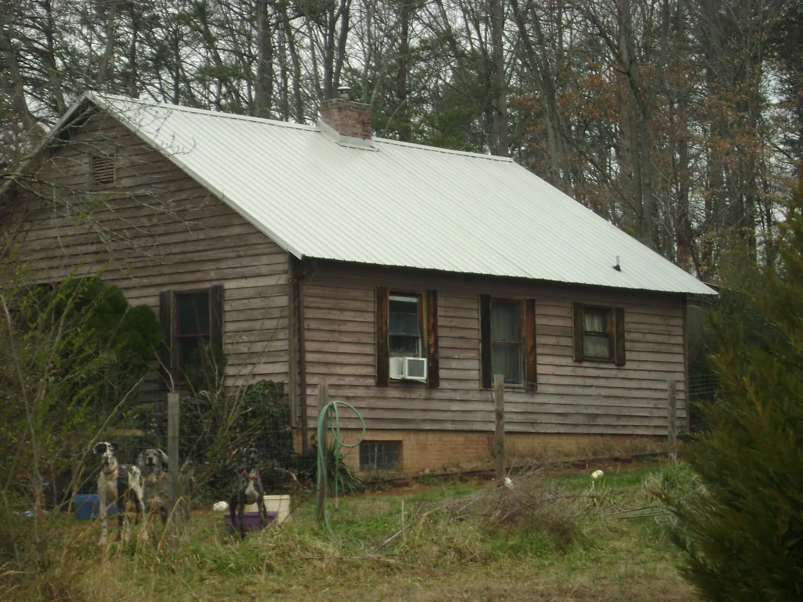 White metal roof on an old wood sided farmhouse, from a Metal Roof Installation job in Hanahan